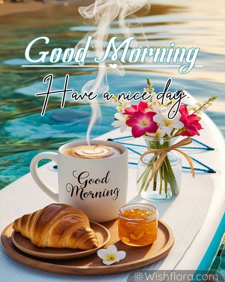 Good Morning Images of a peaceful breakfast by the water with a steaming mug, croissant, orange marmalade, tropical flowers, and turquoise reflections, inspiring tranquil good morning blessings.